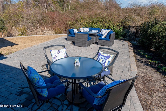 view of patio / terrace featuring outdoor dining space, an outdoor living space, and fence