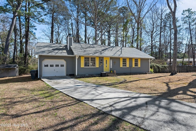 single story home with a garage, fence, driveway, a chimney, and a front yard