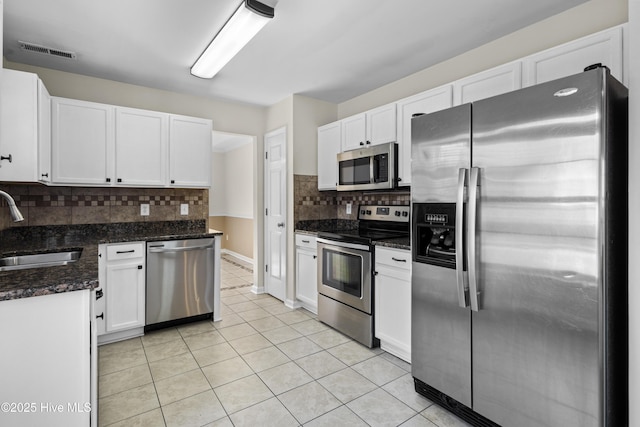 kitchen featuring light tile patterned floors, visible vents, appliances with stainless steel finishes, white cabinetry, and a sink