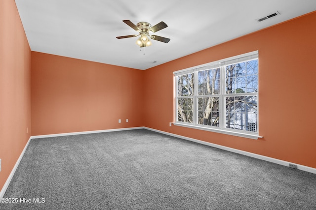 carpeted empty room featuring a ceiling fan, visible vents, and baseboards