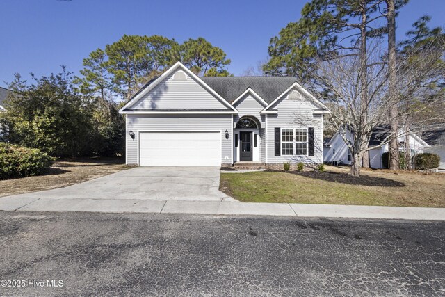 view of front of property with concrete driveway, an attached garage, and a front yard