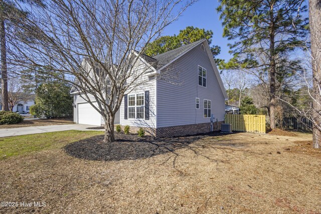 traditional-style house featuring a garage, a front lawn, and concrete driveway