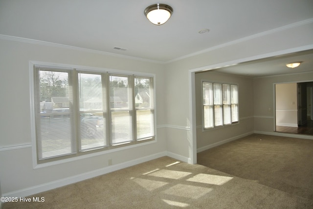 spare room with baseboards, crown molding, visible vents, and carpet flooring