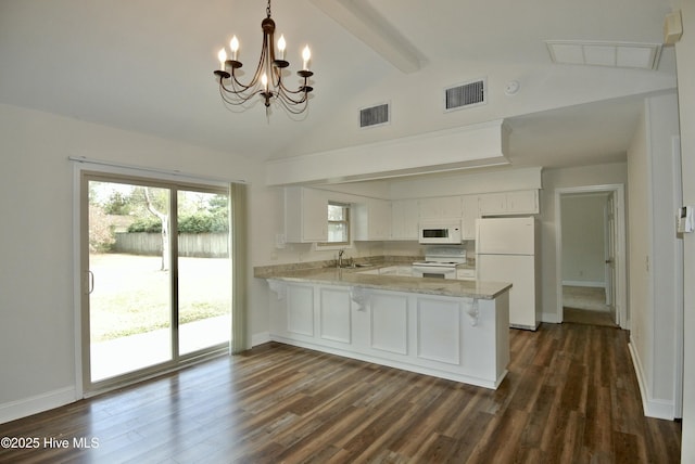 kitchen featuring white appliances, visible vents, a sink, and a peninsula