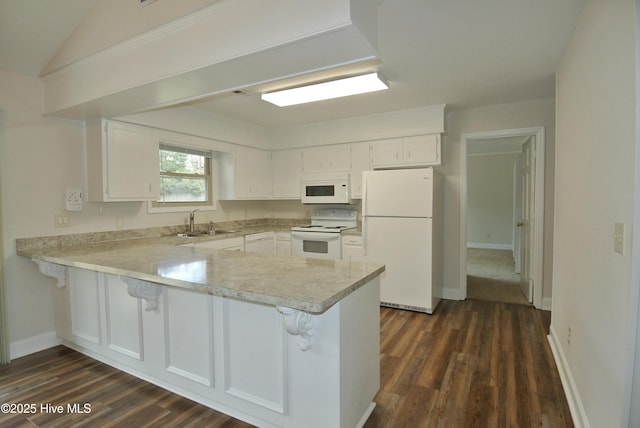 kitchen featuring a sink, a peninsula, white appliances, and light countertops