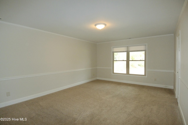 unfurnished room featuring baseboards, light colored carpet, and crown molding