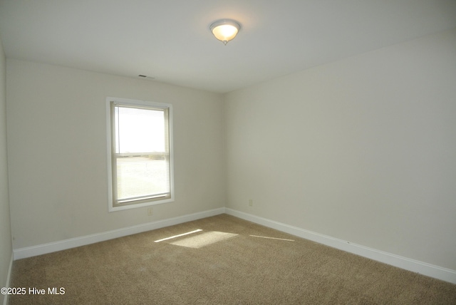 unfurnished room with light colored carpet, visible vents, and baseboards