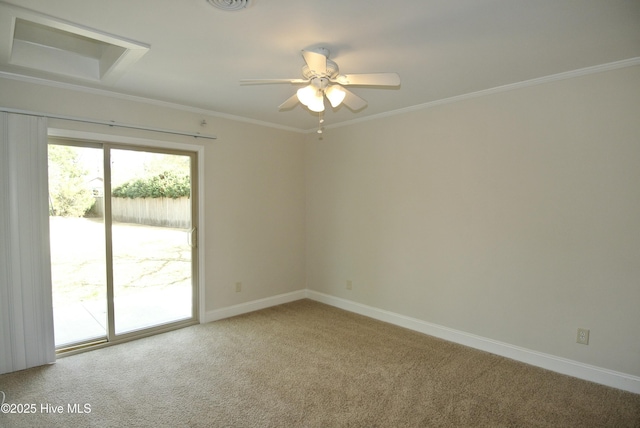 spare room with ceiling fan, light colored carpet, visible vents, baseboards, and ornamental molding