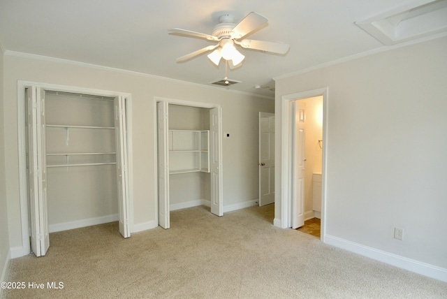 unfurnished bedroom with light carpet, visible vents, baseboards, two closets, and crown molding