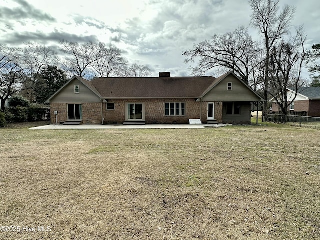 rear view of house with entry steps, brick siding, a patio area, and fence