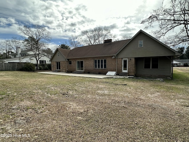 back of property featuring brick siding, a chimney, entry steps, a patio area, and fence