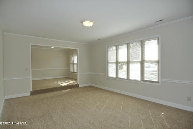 unfurnished room featuring baseboards, ornamental molding, visible vents, and light colored carpet