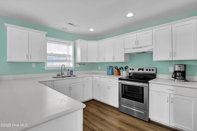 kitchen with electric stove, white cabinetry, a sink, and under cabinet range hood