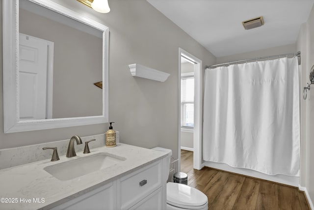 bathroom featuring shower / bath combo with shower curtain, vanity, toilet, and wood finished floors