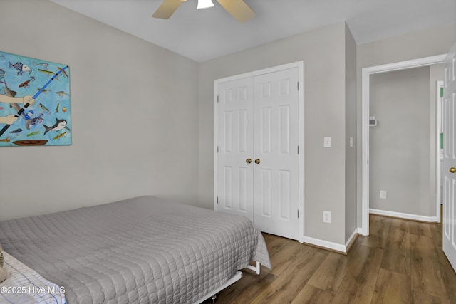 bedroom featuring ceiling fan, a closet, wood finished floors, and baseboards