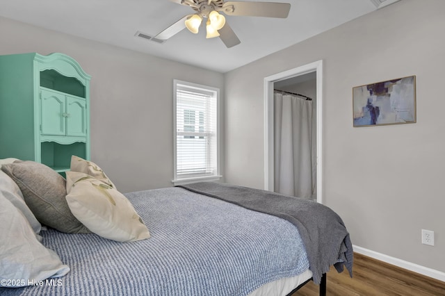 bedroom with visible vents, ceiling fan, baseboards, and wood finished floors