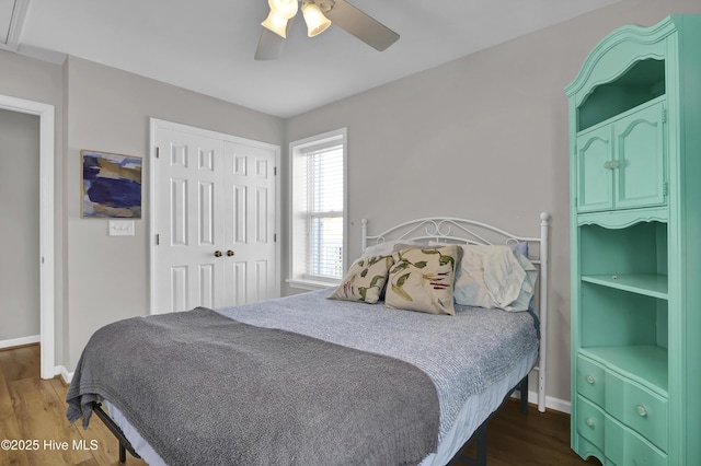 bedroom featuring dark wood-style floors, a closet, ceiling fan, and baseboards