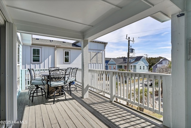 wooden terrace featuring a residential view and outdoor dining area