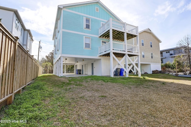 back of house featuring a carport and a lawn