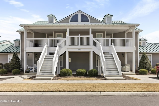 coastal inspired home featuring a porch, metal roof, stairs, and a standing seam roof