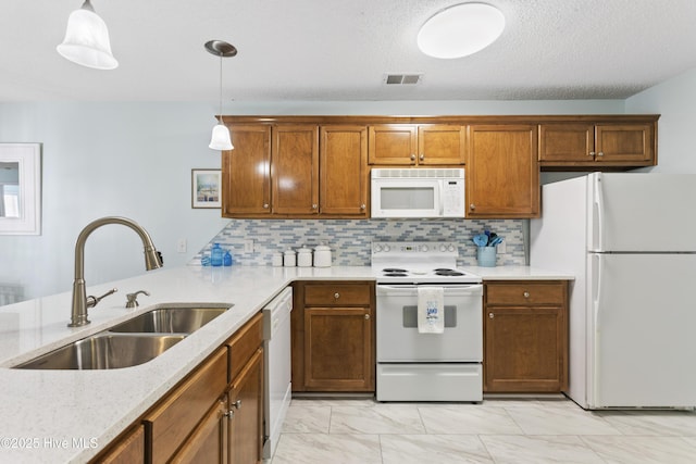 kitchen with white appliances, brown cabinetry, a sink, hanging light fixtures, and marble finish floor