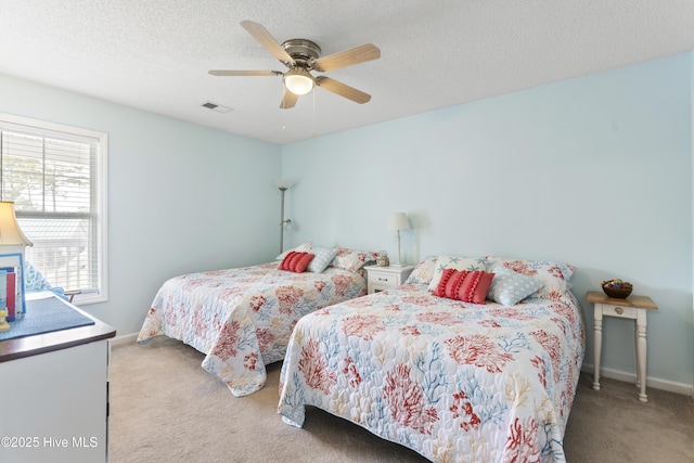 bedroom featuring visible vents, a textured ceiling, carpet flooring, baseboards, and ceiling fan