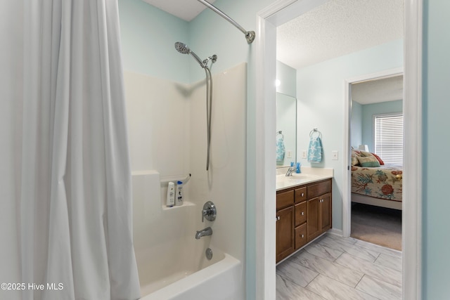 ensuite bathroom featuring vanity, shower / bathtub combination with curtain, a textured ceiling, marble finish floor, and connected bathroom