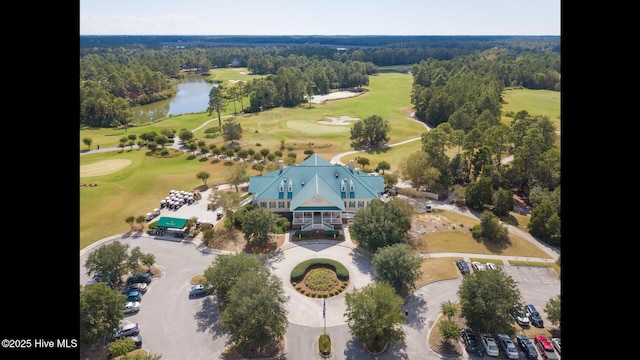 drone / aerial view with a forest view, a water view, and view of golf course