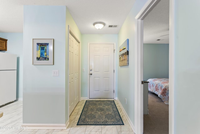 interior space with baseboards, visible vents, and a textured ceiling