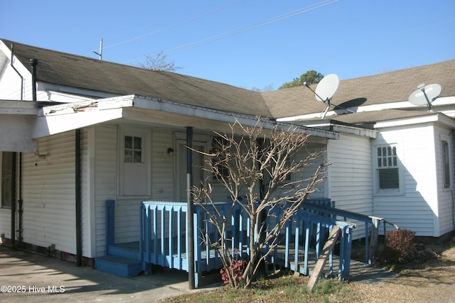 view of home's exterior featuring a shingled roof and a porch