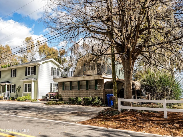 view of front of home with a fenced front yard and a balcony