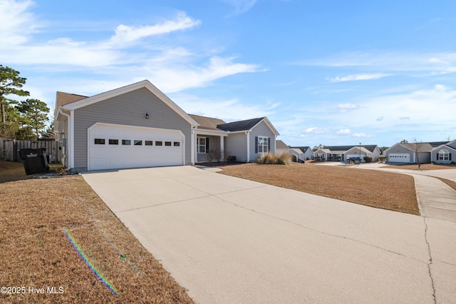 ranch-style home with a garage, driveway, fence, and a front lawn