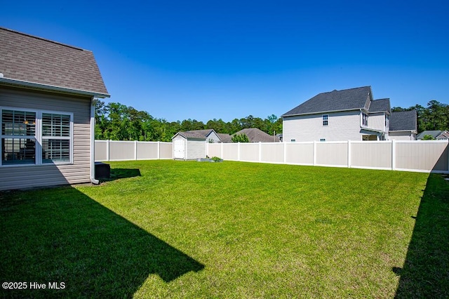 view of yard featuring an outdoor structure, a fenced backyard, and a shed