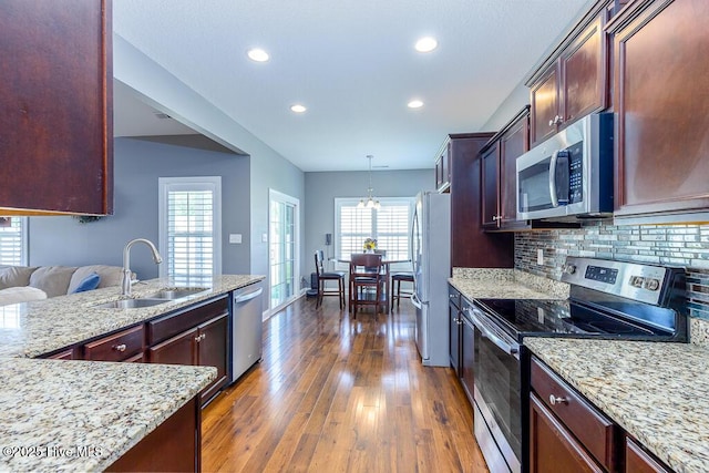 kitchen with tasteful backsplash, a sink, dark wood-style floors, stainless steel appliances, and recessed lighting