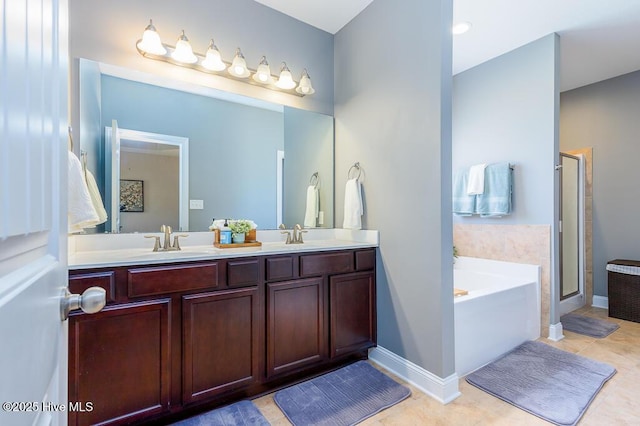 full bath featuring baseboards, a bath, tile patterned floors, a shower stall, and a sink