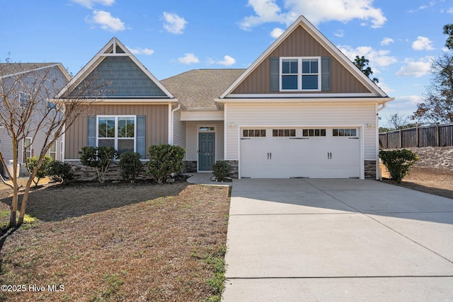 craftsman inspired home with a garage, fence, concrete driveway, stone siding, and board and batten siding