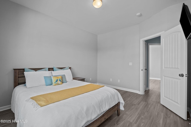 bedroom with baseboards and wood finished floors