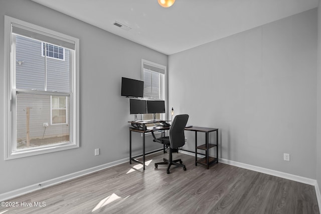 home office featuring visible vents, baseboards, and wood finished floors