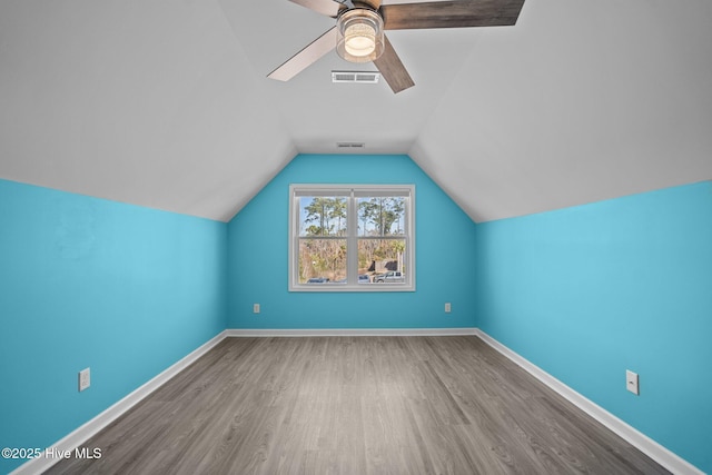 additional living space featuring lofted ceiling, visible vents, baseboards, and wood finished floors