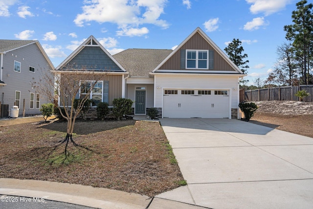 craftsman-style house featuring a garage, fence, driveway, stone siding, and board and batten siding