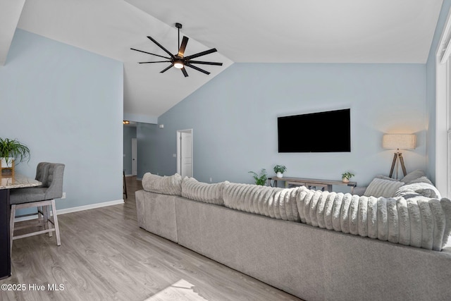 living room featuring a ceiling fan, high vaulted ceiling, baseboards, and wood finished floors