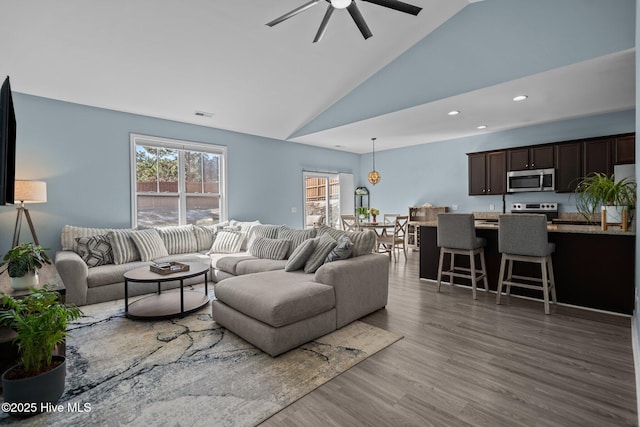 living area featuring visible vents, a ceiling fan, wood finished floors, high vaulted ceiling, and recessed lighting