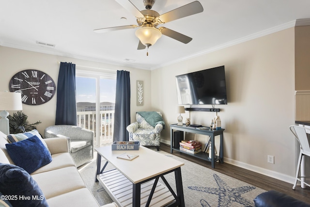 living area featuring ornamental molding, visible vents, baseboards, and wood finished floors