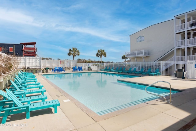 community pool with a patio and fence