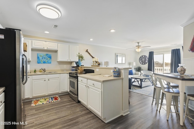 kitchen with visible vents, white cabinets, appliances with stainless steel finishes, dark wood-style flooring, and a peninsula