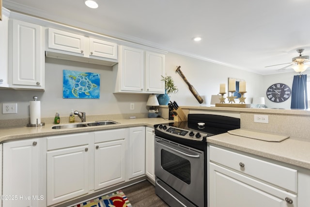 kitchen with electric range, white cabinets, a sink, and light countertops