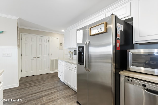 kitchen featuring stainless steel appliances, dark wood-type flooring, white cabinets, light countertops, and ornamental molding