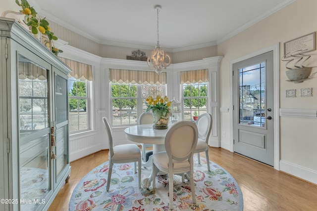 dining space with a chandelier, ornamental molding, baseboards, and light wood-style floors