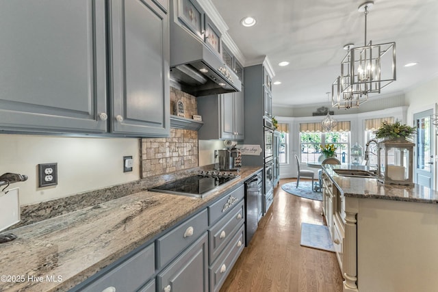 kitchen with gray cabinetry, ornamental molding, a sink, under cabinet range hood, and black electric cooktop