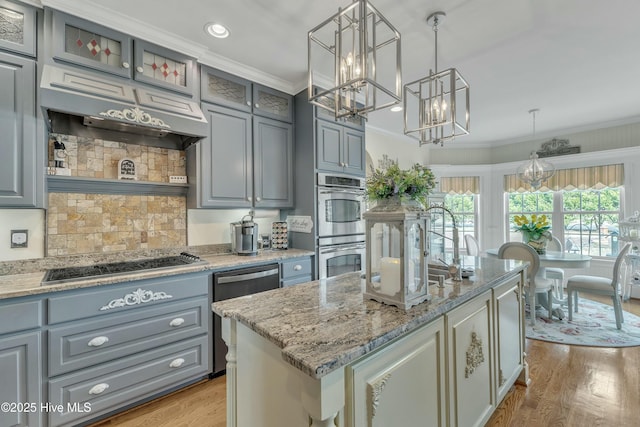 kitchen with appliances with stainless steel finishes, gray cabinets, light wood-style floors, and crown molding